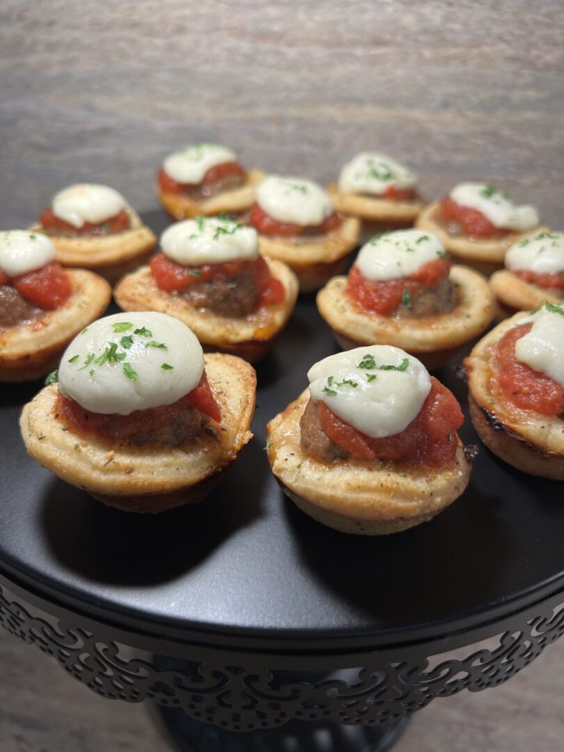 Mini mushroom caps stuffed with tomato sauce and topped with mozzarella and herbs.
