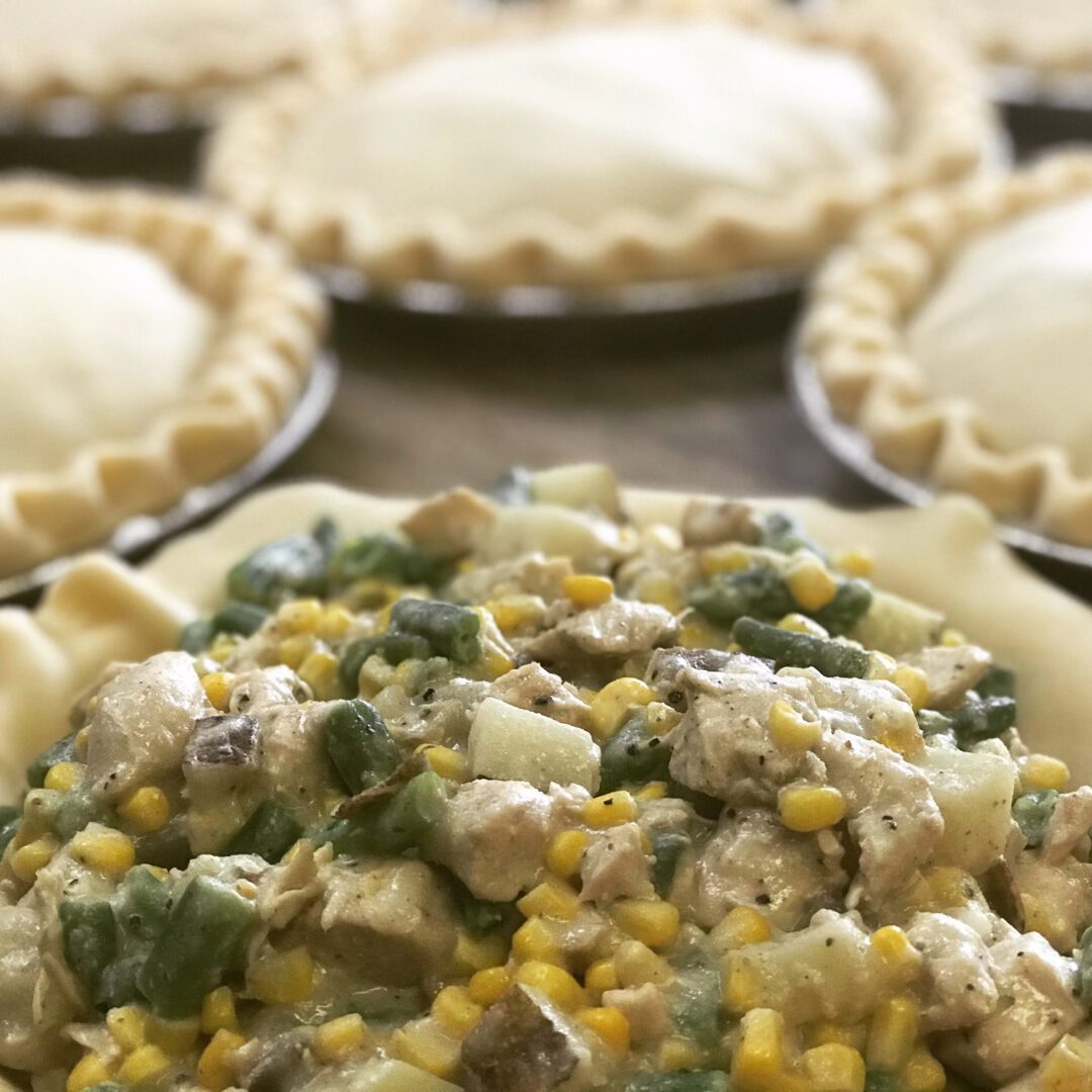 Unbaked savory pies filled with a colorful vegetable and meat mixture.