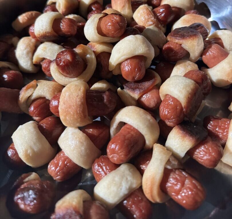 Mini sausages wrapped in dough, baked to golden perfection.