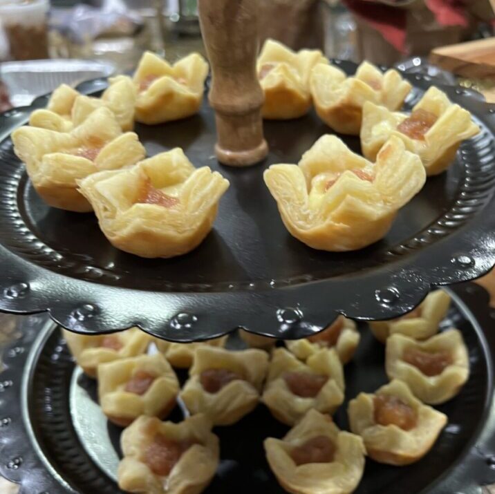 Two-tiered tray with bite-sized savory appetizers on a kitchen counter.